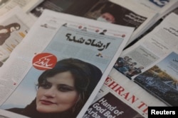 A newspaper with a cover picture of Mahsa Amini, a woman who died after being arrested by Iranian morality police is seen in Tehran, Iran, Sept. 18, 2022. (West Asia News Agency via Reuters)