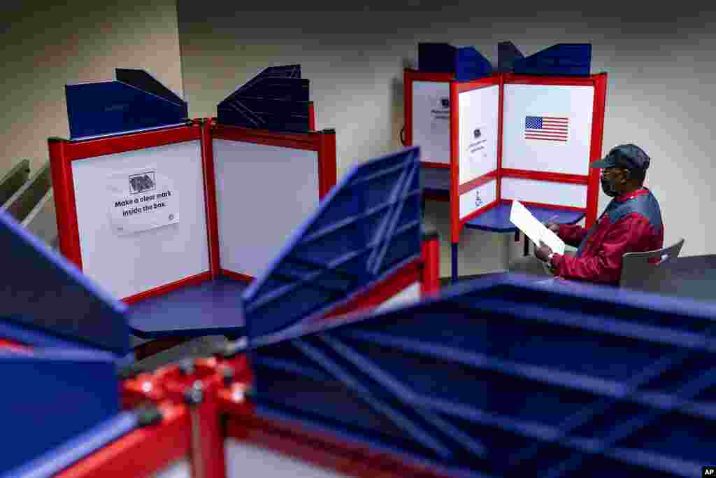 Cornelius Whiting fills out his ballot at an early voting location in Alexandria, Va. In-person voting for the midterm elections has started in Minnesota, South Dakota, Virginia and Wyoming.