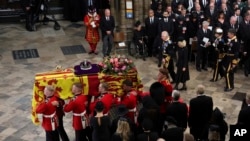 Britain's Queen Elizabeth's coffin is carried as Britain's King Charles III, Camilla, the Queen Consort and Princess Anne follow, on the day of the state funeral and burial of Britain's Queen Elizabeth, at Westminster Abbey, in London, Sept. 19, 2022. 