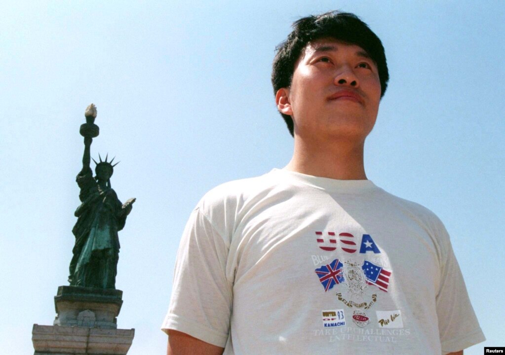 一名中国游客站在北京的主题公园竖立的纽约自由女神像前拍照。那个年代的中国民众还很难得到出国旅游的护照。（1998年6月19日）(photo:VOA)