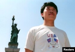 一名中國遊客站在北京的主題公園豎立的紐約自由女神像前拍照。那個年代的中國民眾還很難得到出國旅遊的護照。（1998年6月19日）