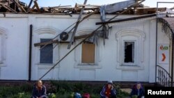 Locals sell vegetables in front of a damaged market in Balakliia, recently liberated by Ukrainian Armed Forces, in Kharkiv region.