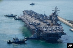 The U.S. carrier USS Ronald Reagan is escorted as it arrives in Busan, South Korea, Friday, Sept. 23, 2022. The nuclear-powered aircraft carrier arrived in Busan port on Friday ahead of the two countries' joint military exercise that aims to show their strength against growing North Korean threats.
