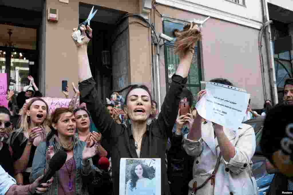 An Iranian woman living in Turkey reacts after she cut her hair during a protest following the death of Mahsa Amini, outside the Iranian consulate in Istanbul, Turkey, Sept. 21, 2022.