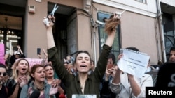 An Iranian woman living in Turkey reacts after she cut her hair during a protest following the death of Mahsa Amini, outside the Iranian consulate in Istanbul, Turkey Sept. 21, 2022. 