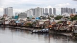 FILE - Houses are seen on the banks of the Te canal in Ho Chi Minh City, Vietnam, Sept. 17, 2018. Sprawling coastal cities in South and Southeast Asia are sinking faster than elsewhere in the world.