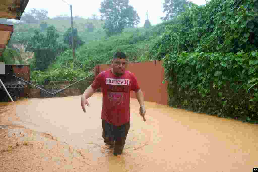 Un hombre camina por una carretera inundada por el huracán Fiona en Cayey, Puerto Rico, el domingo 18 de septiembre de 2022. (Foto AP/Stephanie Rojas)