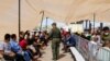 Migrantes que buscan asilo esperan en una nueva Unidad Móvil de Procesamiento en Ruta (MERC), utilizada por la Patrulla Fronteriza de EEUU en El Paso, Texas, el 21 de septiembre de 2022.