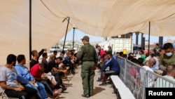 Migrantes que buscan asilo esperan en una nueva Unidad Móvil de Procesamiento en Ruta (MERC), utilizada por la Patrulla Fronteriza de EEUU en El Paso, Texas, el 21 de septiembre de 2022.