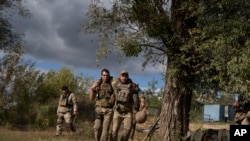 Un militar ucraniano ayuda a un compañero durante una evacuación de soldados heridos que participan en la contraofensiva en una región cercana a la aldea recuperada de Shchurove, Ucrania, el 25 de septiembre de 2022.