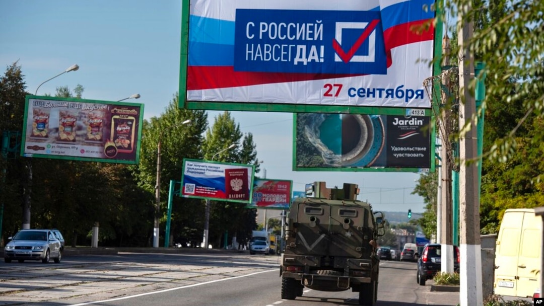 Rusko vojno vozilo prolazi ulicom pored bilborda na kom piše "Sa Rusijom zauvijek, 27. septembar", pred referendum u Lugansku, teritoriji pod kontrolom proruskih separatista, u ističnoj Ukrajini, 22. septembra 2022.