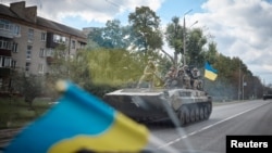 Ukrainian service members ride on an armored fighting vehicle in the town of Kupiansk, recently liberated by the Armed Forces, amid Russia's attack on Ukraine, in Kharkiv region, Ukraine, in this handout picture released Sept. 19, 2022. (Ukrainian Preside