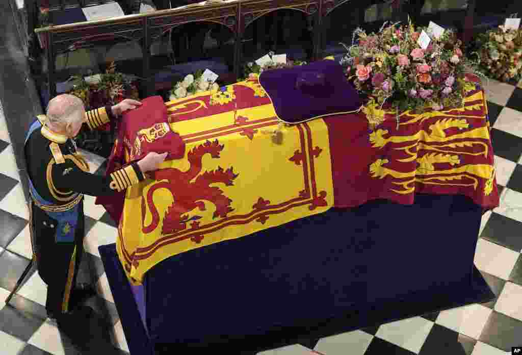 King Charles III places the Queen's Company Camp Colour of the Grenadier Guards on the coffin at the Committal Service for Queen Elizabeth II, held at St. George's Chapel in Windsor Castle, Sept. 19, 2022.