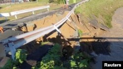 A part of a street collapses into a river in Fukuroi, Shizuoka Prefecture, Japan, Sept. 24, 2022 in this image from a social media video.