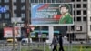A billboard promoting contract army service with an image of a serviceman and the slogan reading "Serving Russia is a real job" is seen on display in St. Petersburg, Sept. 20, 2022. 