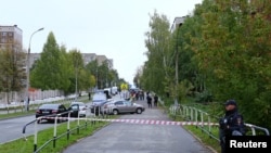 A police officer secures area after a school shooting in Izhevsk, Russia, Sept. 26, 2022.