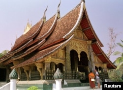 Sebuah kuil Buddha dikunjungi oleh seorang turis barat di ibu kota kerajaan lama Laos, Luang Prabang. (Foto: Reuters)