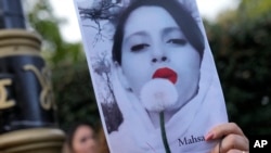 Demonstranti u Londonu drže fotografiju Mahse Amini, 22-godišnje žene koja je umrla posle hapšenja jer nije nosila hidžab kako propisuje "moralna policija"