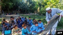 আফগান শিশুরা নানগারহার প্রদেশের দক্ষিণাঞ্চলে উন্মুক্ত স্থানে একটি স্কুলে ক্লাস করছে। ৪ সেপ্টেম্বর, ২০২২। ফাইল ছবি। 