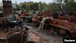 Ukrainian serviceman checks a destroyed Russian Armoured Personnel Carrier (APC), as Russia's attack on Ukraine continues, in the town of Izium, recently liberated by Ukrainian Armed Forces, in Kharkiv region, Ukraine Sept. 20, 2022.