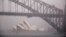 FILE - A boat passes under the Sydney Harbour Bridge and in front of the Sydney Opera House as strong winds and heavy rain hit the city of Sydney, Australia, Nov. 28, 2018. 