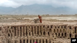 Afghan children work in a brick factory on the outskirts of Kabul, Afghanistan, July 23, 2022.