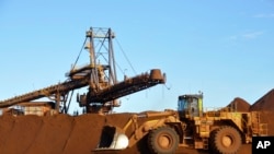 FILE - Earth moving equipment work at the site of Fortescue Metals Group's Christmas Creek iron ore operations in the Pilbara region of Western Australia, June 17, 2014.