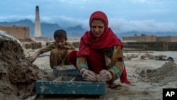 FILE - Afghan children work in a brick factory on the outskirts of Kabul, Afghanistan, Aug. 17, 2022.