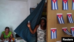 Seorang warga tampak keluar dari stan pemilihan di sebuah tempat pemungutan suara di Havana, Kuba, dalam pemungutan suara referendum mengenai undang-undang keluarga pada 25 September 2022. (Foto: Reuters/Alexandre Meneghini)