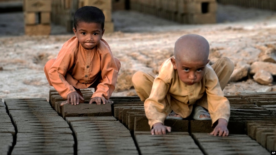 FILE - Afghan children work in a brick factory on the outskirts of Kabul, Afghanistan, July 26, 2022.