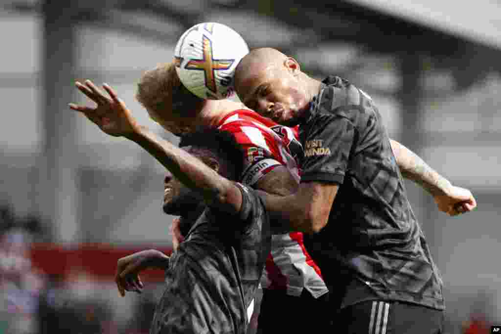 Brentford&#39;s Mathias Jensen, center, goes for the header with Arsenal&#39;s Thomas Partey, left, and his teammate Gabriel during the English Premier League soccer match between Brentford and Arsenal, at the Gtech Community stadium, London.