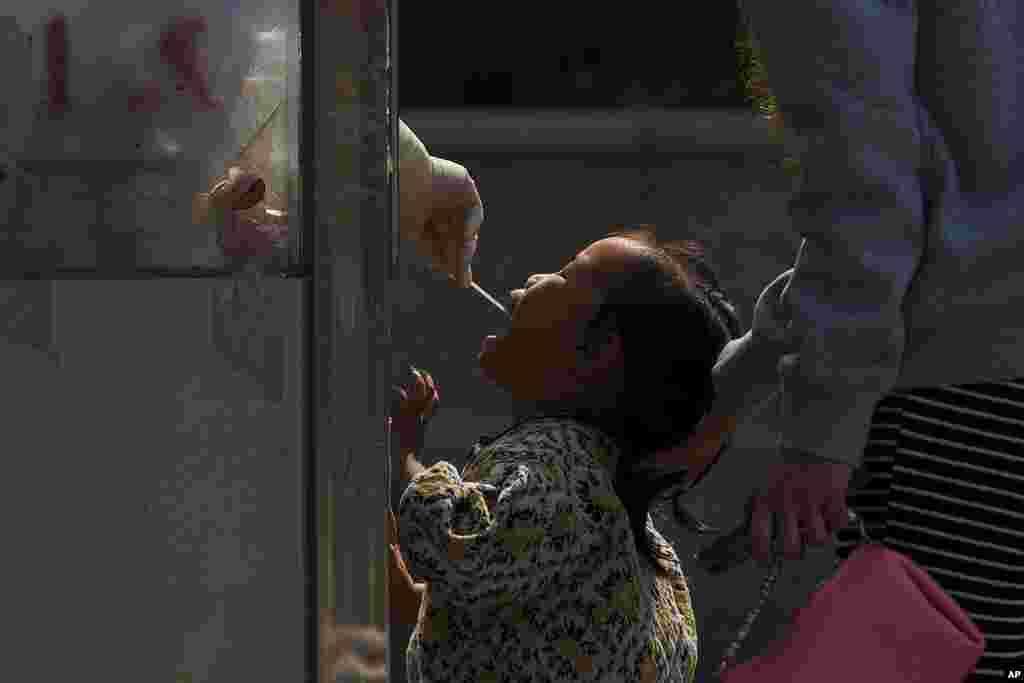 A child gets a routine COVID-19 throat swab at a coronavirus testing site in Beijing.