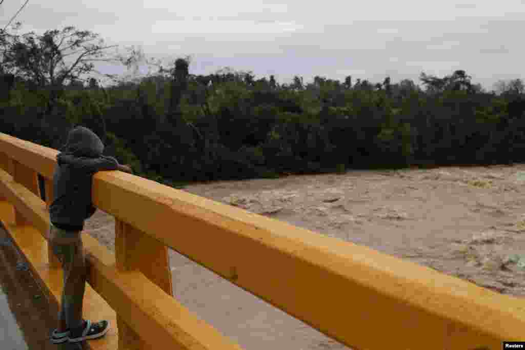 A boy looks at the Chavon River in the aftermath of Hurricane Fiona in Higuey, Dominican Republic, Sept. 19, 2022. 