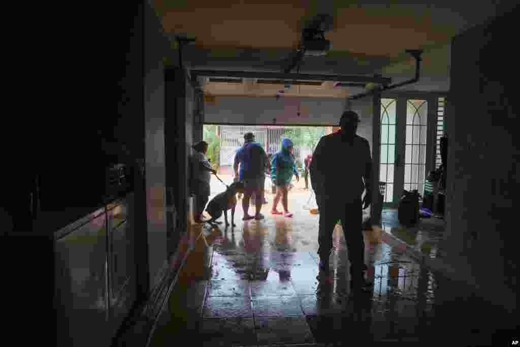 Personas limpian una casa inundada por las lluvias del huracán Fiona en Cayey, Puerto Rico, el domingo 18 de septiembre de 2022. (Foto AP/Stephanie Rojas)