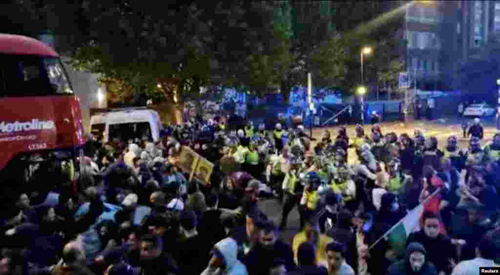 Police confront protesters during demonstrations following the death of Mahsa Amini in Iran, in London, on Sept. 25, 2022, in this screen grab obtained social media video. Obtained By Reuters