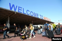 Turistas, provenientes principalmente de Rusia, salen de la terminal de llegadas del Aeropuerto Internacional de Antalya en la ciudad turística mediterránea de Antalya, Turquía, el 22 de septiembre de 2022.