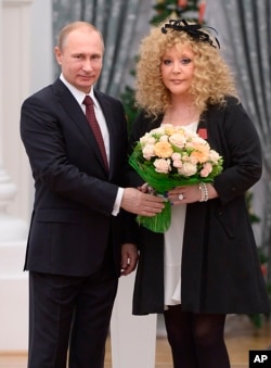 FILE - Russian President Vladimir Putin and pop singer Alla Pugacheva pose for a photo during an awards ceremony in Moscow's Kremlin, Dec. 22, 2014.