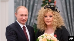 FILE - Russian President Vladimir Putin and pop singer Alla Pugacheva pose for a photo during an awards ceremony in Moscow's Kremlin, Dec. 22, 2014. 