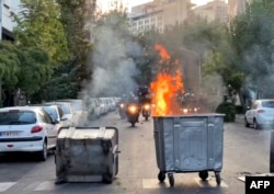 FILE - A bin burns in the middle of an intersection during a protest for Mahsa Amini, a woman who died after being arrested by the Islamic republic's "morality police," in Tehran, Sept. 20, 2022, in this picture obtained by AFP outside Iran.