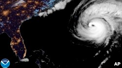 This nighttime image provided by the National Hurricane Center National Oceanic and Atmospheric Administration shows a satellite view as Hurricane Fiona moves up the United States Atlantic coast, Sept. 22, 2022. (NOAA via AP) 