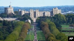 Ljudi se probijaju dugom šetnjom prema vratima Cambridgea ispred dvorca Windsor kako bi položili cvijeće za pokojnu kraljicu Elizabetu II. u Windsoru, Engleska, 18. septembra 2022.