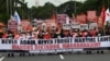 Protesters carry placards as they march during a rally to commemorate 50 years anniversary of the imposition of martial law at the university grounds in Quezon City, suburban Manil, Philippines, Sept. 21, 2022.