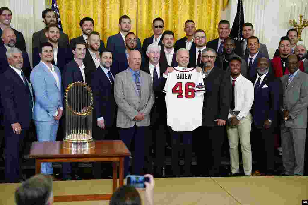 President Joe Biden holds an Atlanta Braves jersey during an event celebrating the Major League Baseball 2021 World Series champion Atlanta Braves in the East Room of the White House.