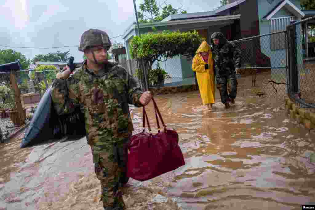 Members of the Puerto Rico National Guard rescue a woman who had been stranded in Hurricane Fiona in Salinas, Puerto Rico, Sept. 19, 2022. 