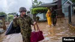 Members of the Puerto Rico National Guard rescue a woman who had been stranded in Hurricane Fiona in Salinas, Puerto Rico, Sept. 19, 2022. 