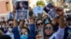 Women hold up pictures of Iranian Mahsa Amini as they shout slogans during a protest against her death, outside Iran's consulate general in Istanbul, Turkey, Sept. 21, 2022. 