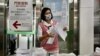 FILE - A staff member checks documents on COVID-19 coronavirus tests at Taoyuan International Airport near Taipei on April 1, 2021, before tourists head to Palau as part of a travel bubble plan.
