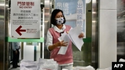 FILE - A staff member checks documents on COVID-19 coronavirus tests at Taoyuan International Airport near Taipei on April 1, 2021, before tourists head to Palau as part of a travel bubble plan.