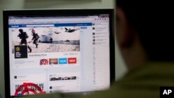 FILE - An Israeli soldier looks at the Facebook page of the Israel Defense Forces in Jerusalem, Nov. 15, 2012. Hostilities between Israel and the Palestinian group Hamas have found a battleground in social media.