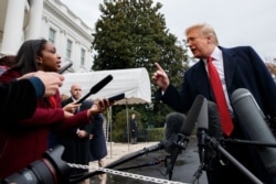 FILE - CNN journalist Abby Phillip asks President Donald Trump a question as he speaks with reporters on the South Lawn of the White House, Nov. 9, 2018.